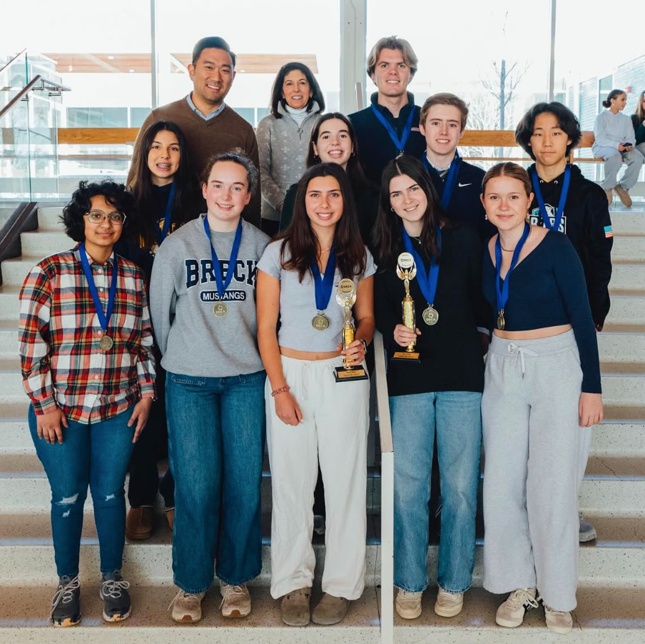 Breck DECA state qualifiers with their medals and trophies from Districts